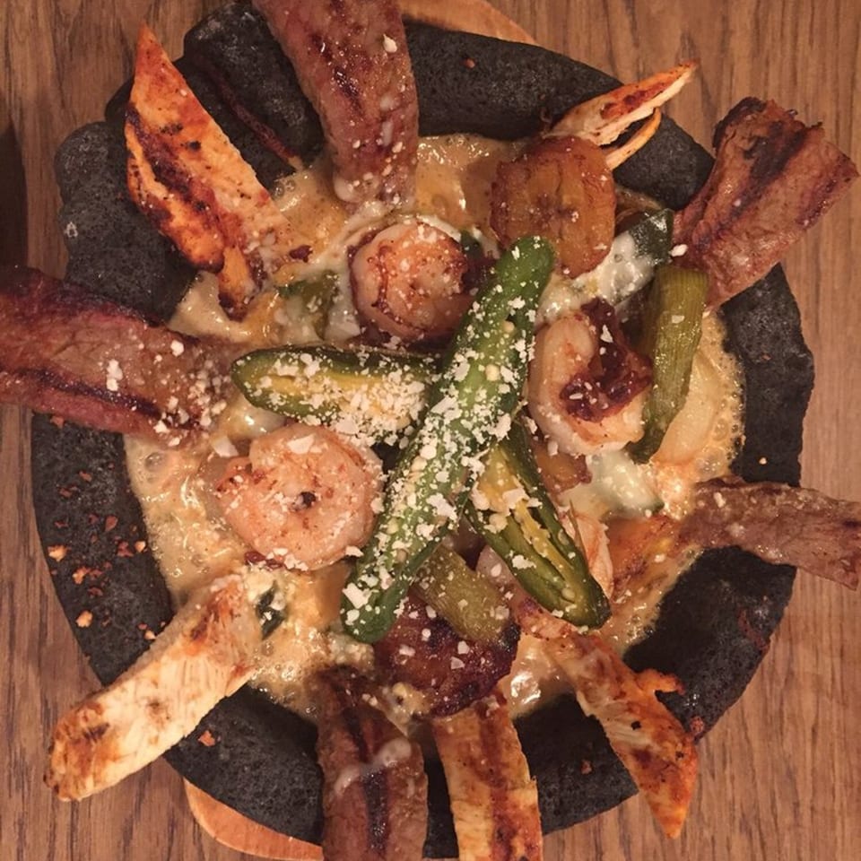 El Rey Azteca's sizzling molcajete with grilled meats, shrimp, jalapeños, and melted cheese.